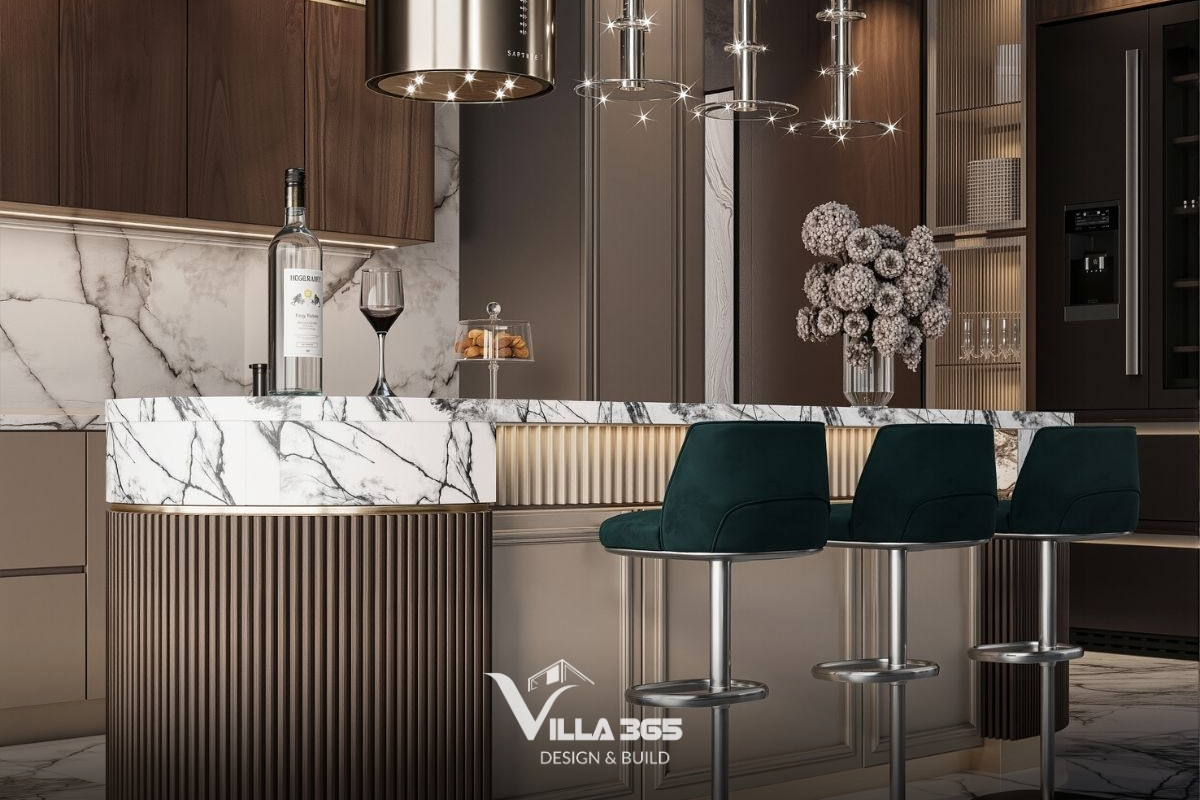 Các đường viền kim loại mạ vàng ở chân quầy bar và cổ quầy phản chiếu lấp lánh, nâng tầm giá trị thẩm mỹ cho căn bếp