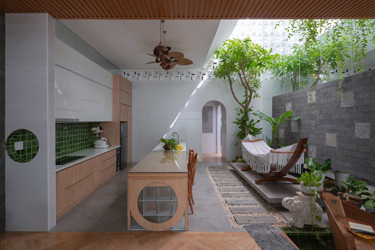 Cửa kính lớn và khoảng mở hướng vườn đưa ánh sáng, cây xanh cùng thông gió tự nhiên vào căn bếp Tropical  (Ảnh: Sưu tầm)